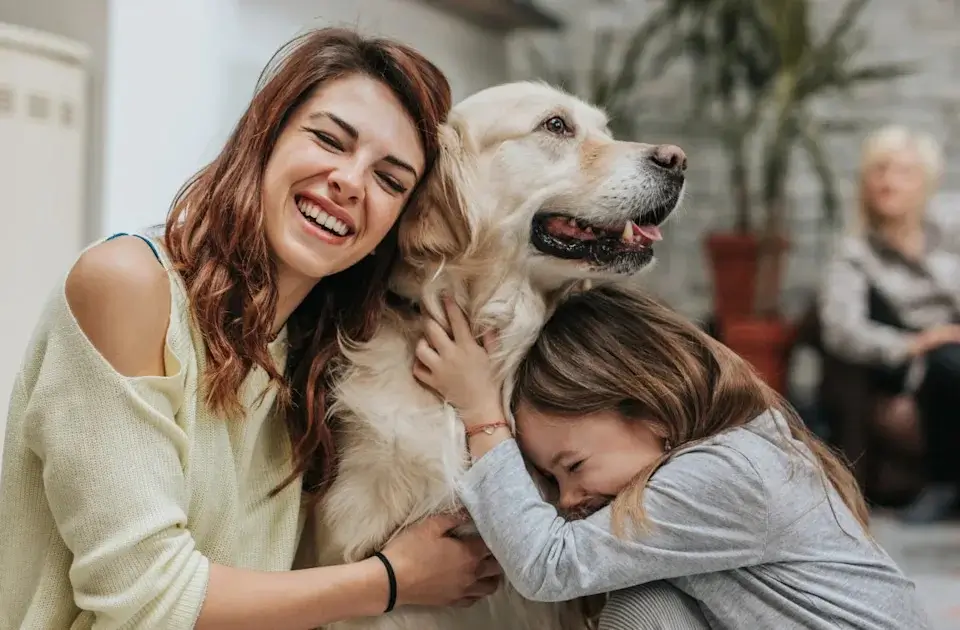A family happily hugging their newly adopted dog